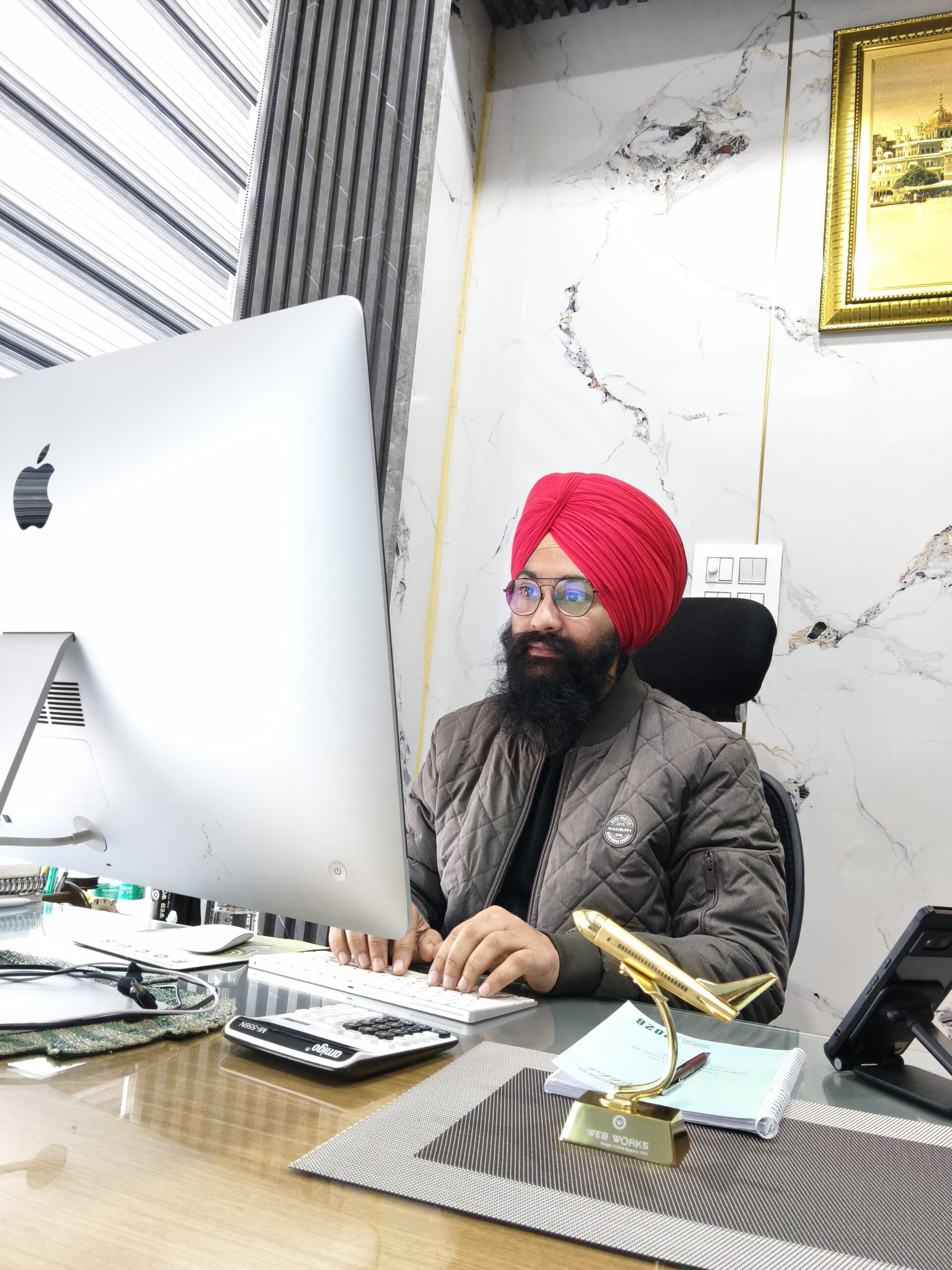 Owner of a Social media marketing company in Punjab working on a computer at the office